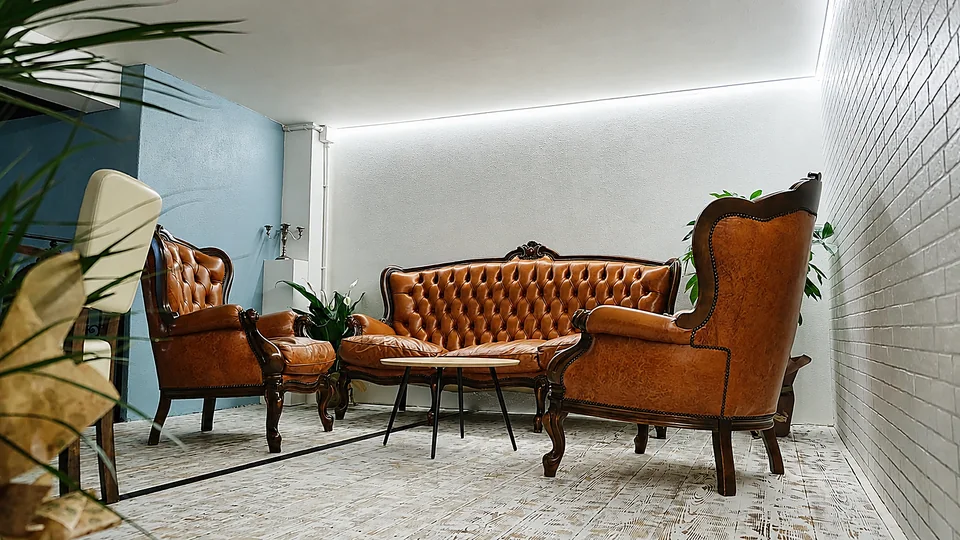 Il salotto vintage del Kairos con divani in pelle e piante