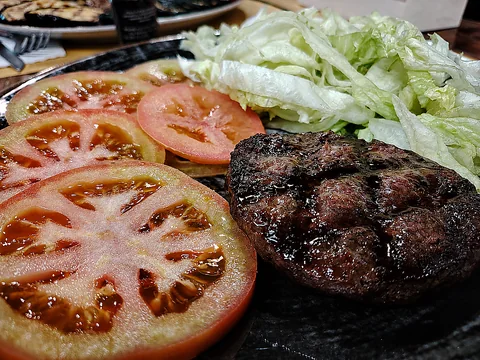 Hamburger di carne grigliato con pomodoro e lattuga